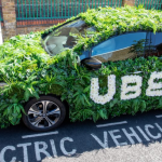 Uber electric taxi covered in green foliage