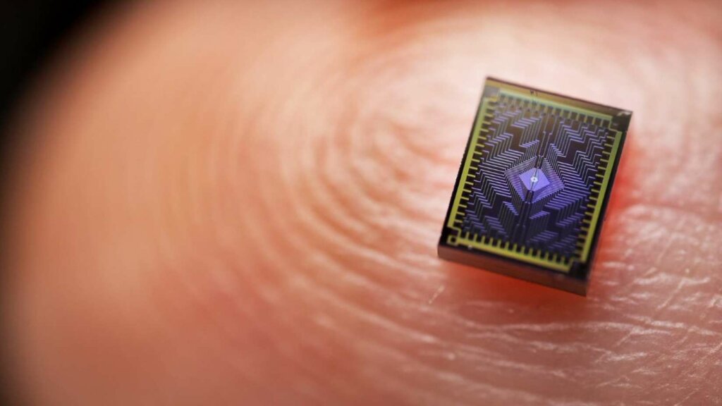 A photo shows one of Intel's Tunnel Falls chips on a human finger to display its scale. Silicon spin qubits are up to 1 million times smaller than other qubit types. The Tunnel Falls chip measures approximately50-nanometers square, potentially allowing for faster scaling. (Credit: Intel Corporation)